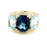 Ring designed with London blue topaz flanked by Sky blue with diamond halo 14kt yellow gold - Gaines Jewelers