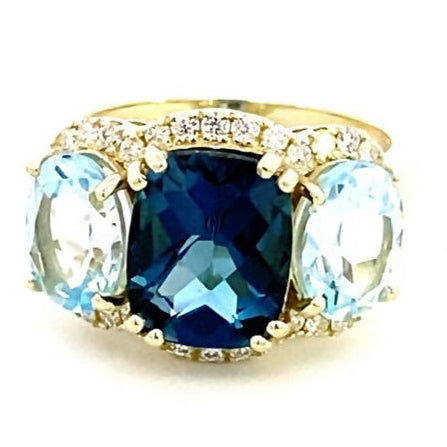 Ring designed with London blue topaz flanked by Sky blue with diamond halo 14kt yellow gold - Gaines Jewelers