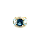 Ring designed with London blue topaz flanked by Sky blue with diamond halo 14kt yellow gold - Gaines Jewelers