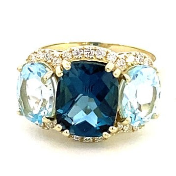Ring designed with London blue topaz flanked by Sky blue with diamond halo 14kt yellow gold - Gaines Jewelers