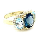 Ring designed with London blue topaz flanked by Sky blue with diamond halo 14kt yellow gold - Gaines Jewelers