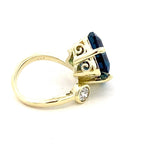 Ring in a bypass style set with a large London blue topaz 14kt yellow gold - Gaines Jewelers
