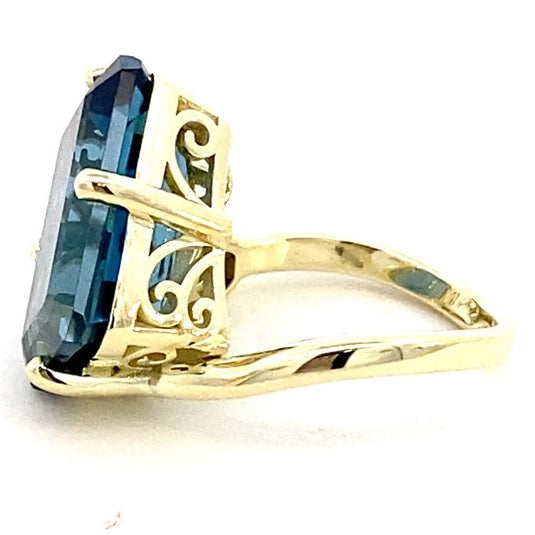 Ring in a bypass style set with a large London blue topaz 14kt yellow gold - Gaines Jewelers