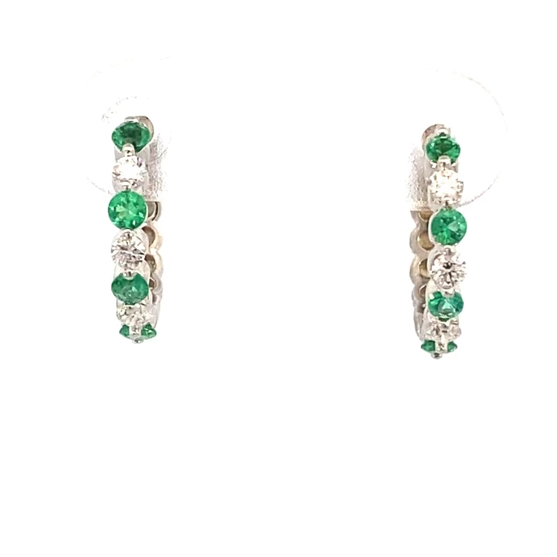 A pair of emerald and diamond tiny hoop earrings in 14kt white gold