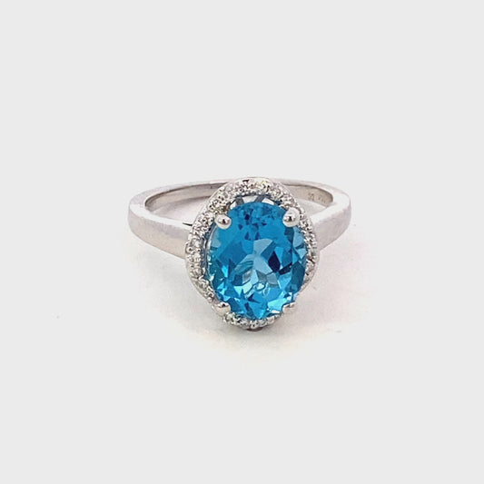 Ring- blue topaz set in a scalloped halo 14kt white gold