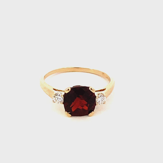 Ring- cushion garnet ring flanked by 2 diamonds 14kt yellow gold