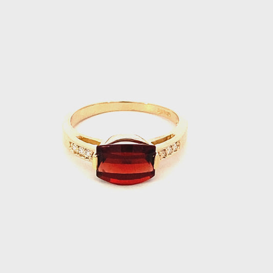 Ring- garnet set east-west flanked by diamond shank 14kt yellow gold