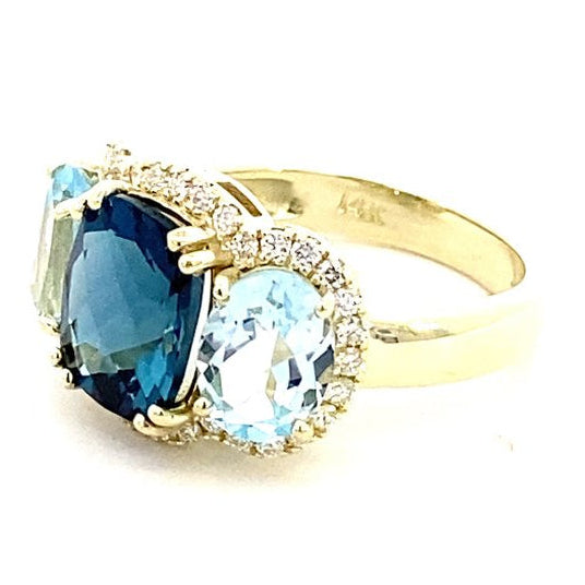 Ring designed with London blue topaz flanked by Sky blue with diamond halo 14kt yellow gold - Gaines Jewelers