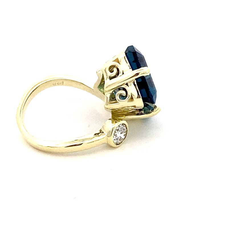 Ring in a bypass style set with a large London blue topaz 14kt yellow gold - Gaines Jewelers