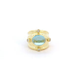 Ring set with a blue topaz & accented with diamonds, wide, in 14kt yellow gold by Raymond Mazza - Gaines Jewelers