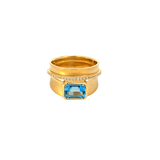 Wide ring set with an emerald cut blur topaz accented with string diamonds in 14kt yellow gold by Marika - Gaines Jewelers